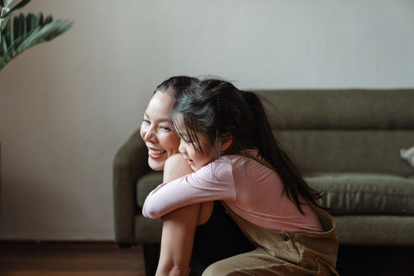 A mother and her young daughter sharing a warm hug at home